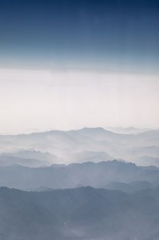 Aerial view of large mountains with mist