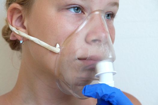 girl breathing through an inhaler, portrait close-up