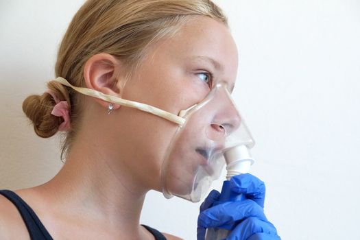 girl breathing through an inhaler, portrait close-up