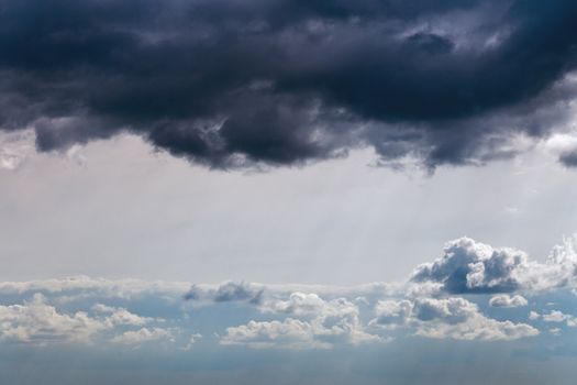 Storm clouds near horizon on blue sky at daylight in continental europe. Shot wit telehoto lens and polarizing filter.