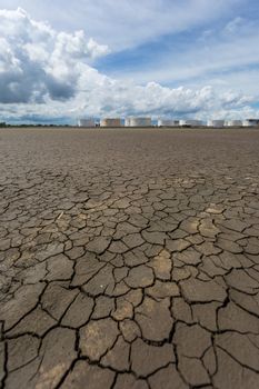 Global worming effect and Oil tanks in a row under blue sky.