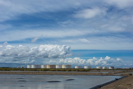 Oil tanks in a row under blue sky, Large white industrial tank for petrol, oil refinery plant. Energy and power.