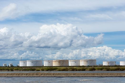 Oil tanks in a row under blue sky, Large white industrial tank for petrol, oil refinery plant. Energy and power.