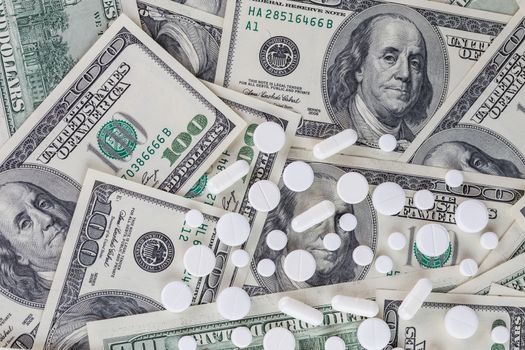 pills flat background, tablets spreaded on a us dollar banknotes - top-down view.