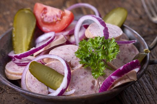 bavarian sausage salad on dark wood