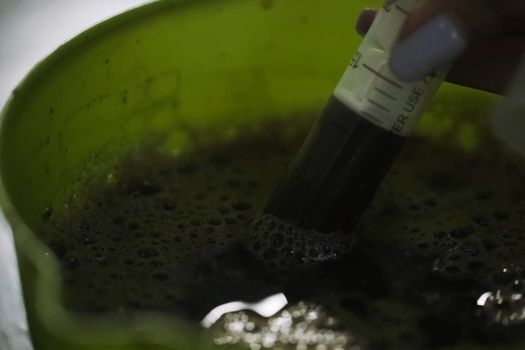 The biological fertilizer is drawn into a syringe. Analyzes in the laboratory.