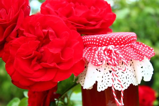 The picture shows rose jelly and blossoming roses