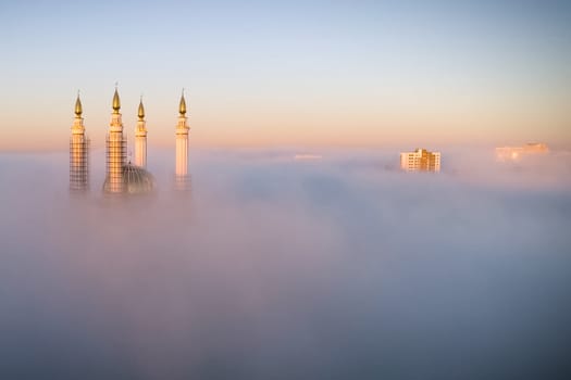 The Kazan Mosque is shrouded in mist at dawn. View from above.