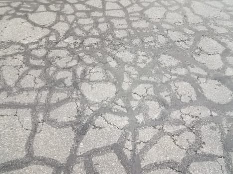 lines in cracked and damaged or worn or weathered black asphalt