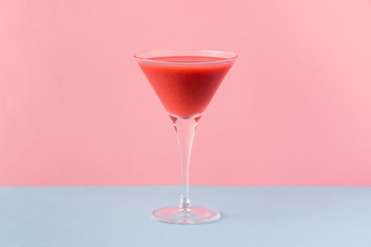 Strawberry smoothie cup on a pink and light blue background. Minimalist image.