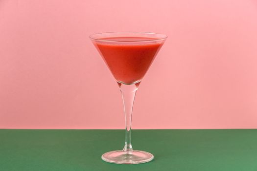 Strawberry smoothie cup on a pink and green background. Minimalist image.