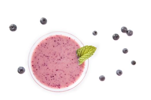 Blueberry smoothie cup with several blueberries on a white background. Top view-