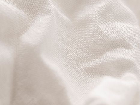 Texture of white fabric shows a soft, comfortable feel. Abstract background.