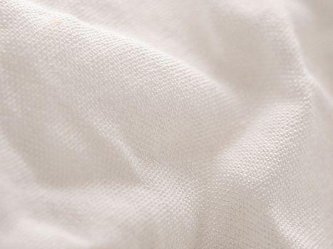 Texture of white fabric shows a soft, comfortable feel. Abstract background.
