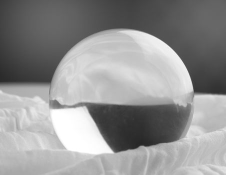 Crystal glass ball sphere transparent on grey gradient background.