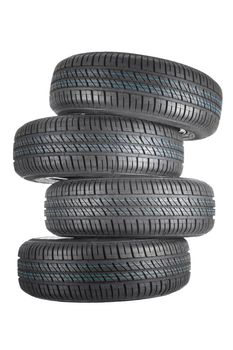 New and unused car tires against white isolated background