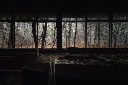 Abandoned building interior with autumnal forest outside in Chernobyl