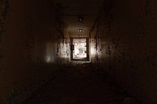 Abandoned hallway with light at the end shining