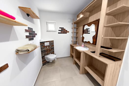 Bathroom in luxury apartment angle shot with wooden furniture