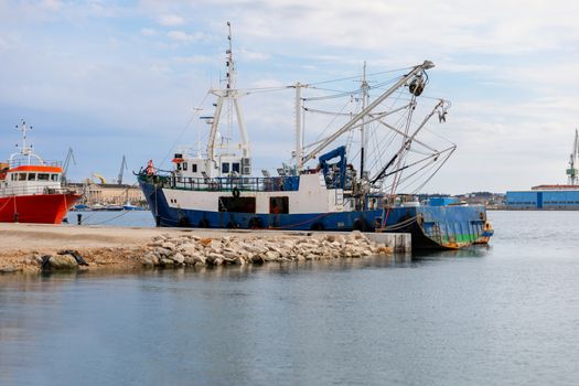 Old fishing boat anchored in the port closeup photo