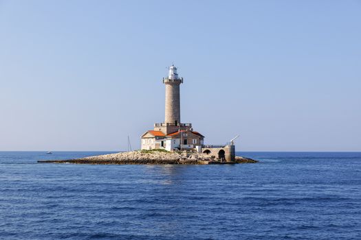 old stone lighthouse on small island closeup photo