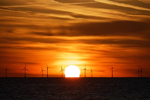 Windfarm on the sea at sunset closeup