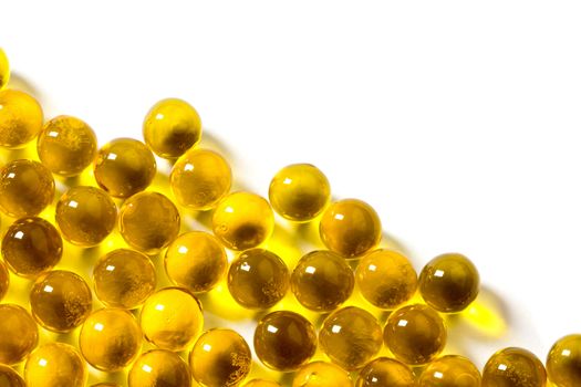 orange spherical ball capsules of fish oil selective focus isolated on white background.