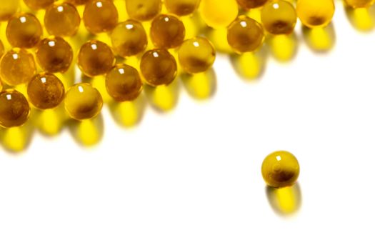 orange spherical ball capsules of fish oil selective focus isolated on white background.