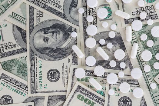 pills flat background, tablets on a us dollar banknotes - top-down view.