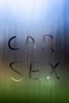 the words car sex written by finger on sweaty window glass - close-up in horizontal orientation