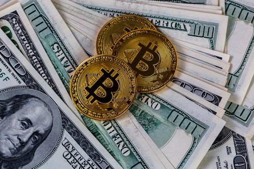 three bitcoin shiners on paper us dollar banknotes background.