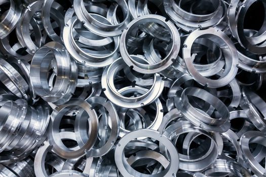 a batch of machined shiny metal parts with selective focus.