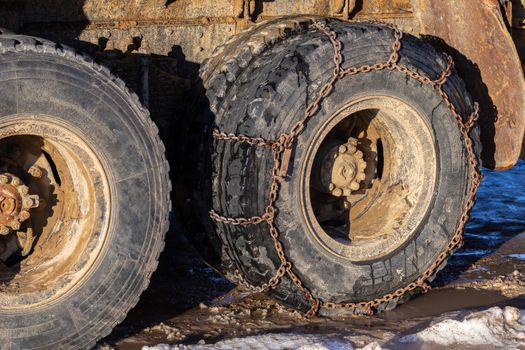 anti-skid chain on freight truck wheels at winter daylight closeup.