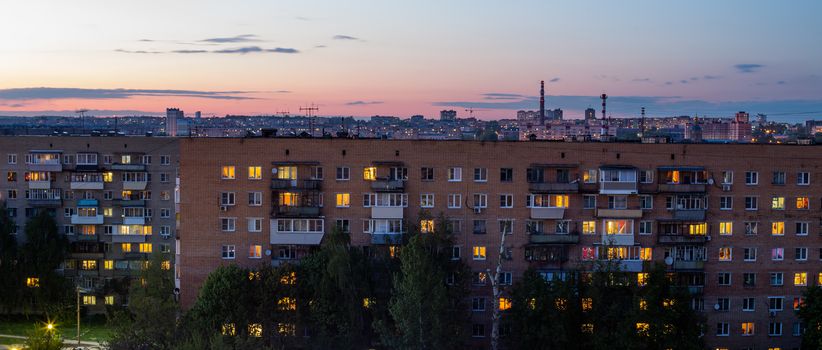 Windows, roofs and facade of an mass brick apartment building in Eastern Europe. Wide panoramic shot.