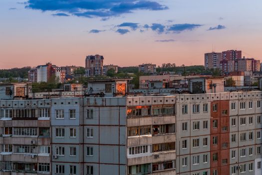 Windows, roofs and facade of an mass apartment buildings in Russia at evening
