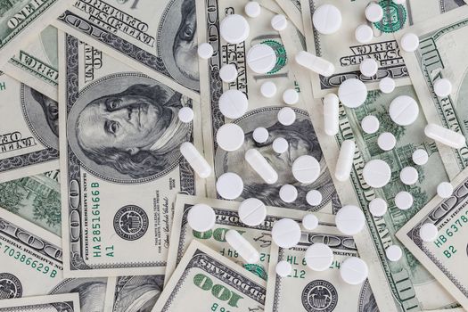 pills flat background, tablets spreaded on a us dollar banknotes - top-down view.