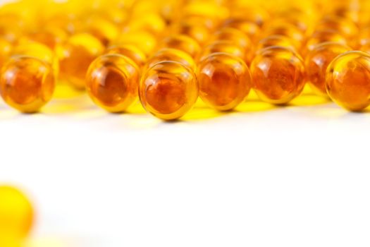 orange spherical ball capsules of fish oil selective focus isolated on white background.