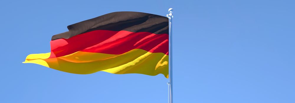 3D rendering of the national flag of Germany waving in the wind against a blue sky