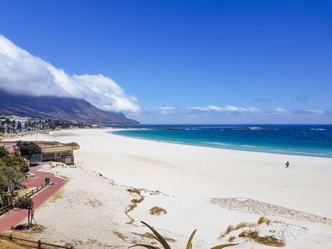 Camps Bay Beach and Table Mountain with clouds in Cape Town, South Africa.