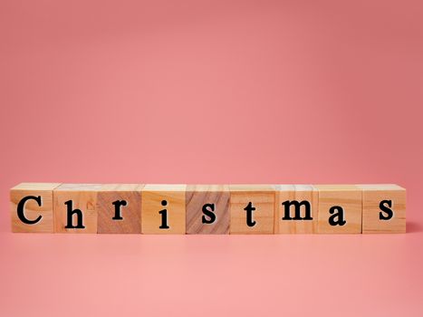 Christmas concept with wooden blocks on pink background. copy space.