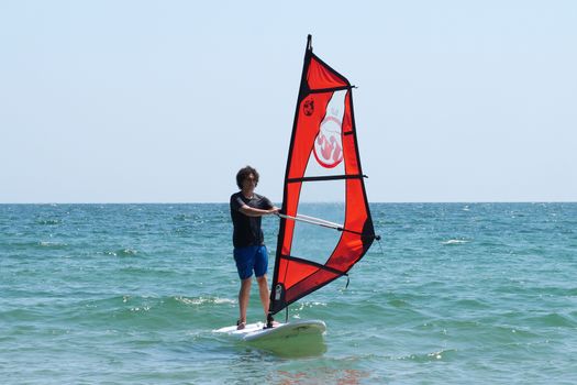 Varna, Bulgaria - July, 31,2020: young guy windsurfing in the sea