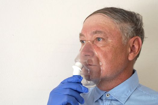 old man breathing through an inhaler, portrait close up