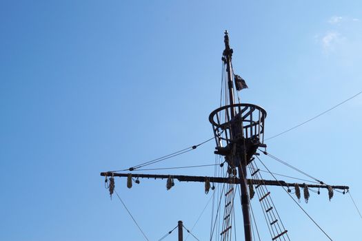 the top of the mast of an old ship against the backdrop of a sunny sky, copy space