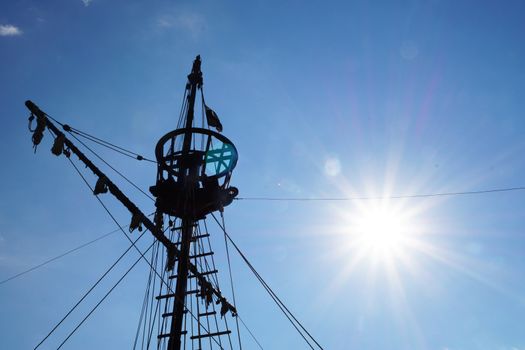 the top of the mast of an old ship against the backdrop of a sunny sky, copy space