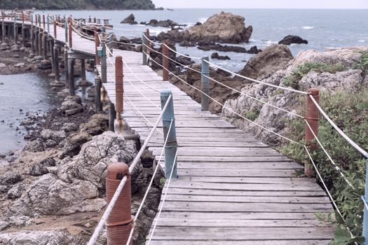 Wooden old bridge boardwalk along on stone