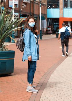 Asian woman wearing a face mask walking around city and shopping