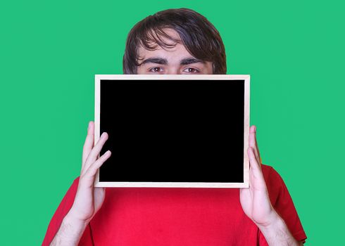 A young man holding Mockup of chalkboard on green background