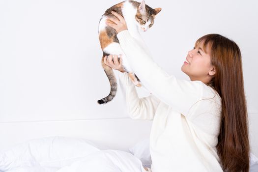 Woman at home holding her lovely fluffy cat. Multicolor tabby cute kitten. Pets and lifestyle concept.