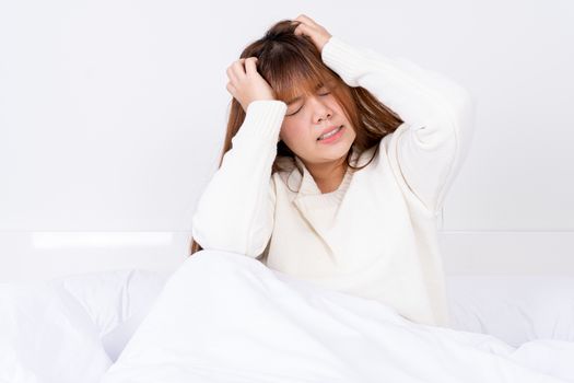 Young woman suffering from headaches after wake up on the bed. Healthcare medical or daily life concept.