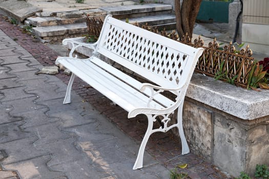 openwork white bench on a pedestrian street close-up